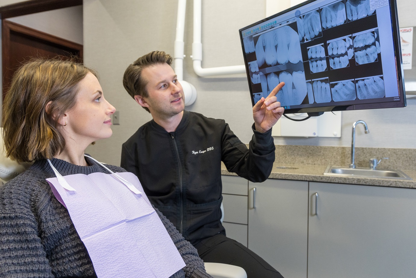 A dentist is showing X-rays to his patient