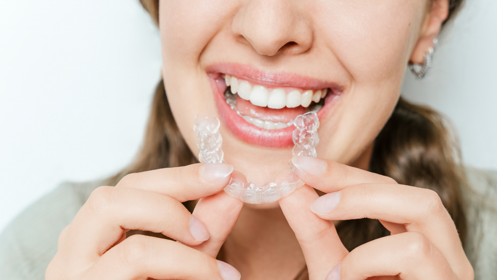 Close-Up Of Smiling Woman Inserting Clear Aligner